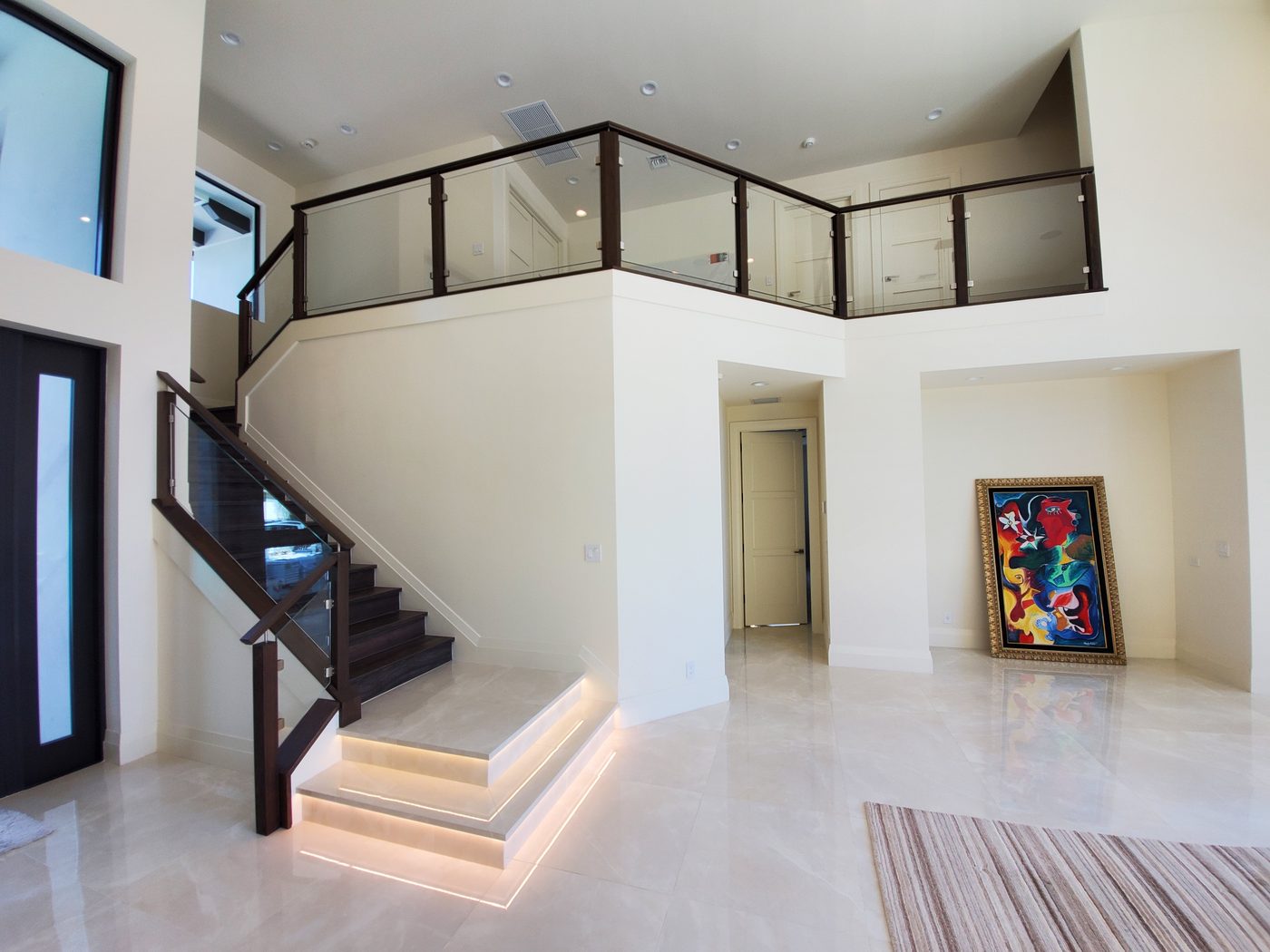 Staircase with glass railing in a bright foyer