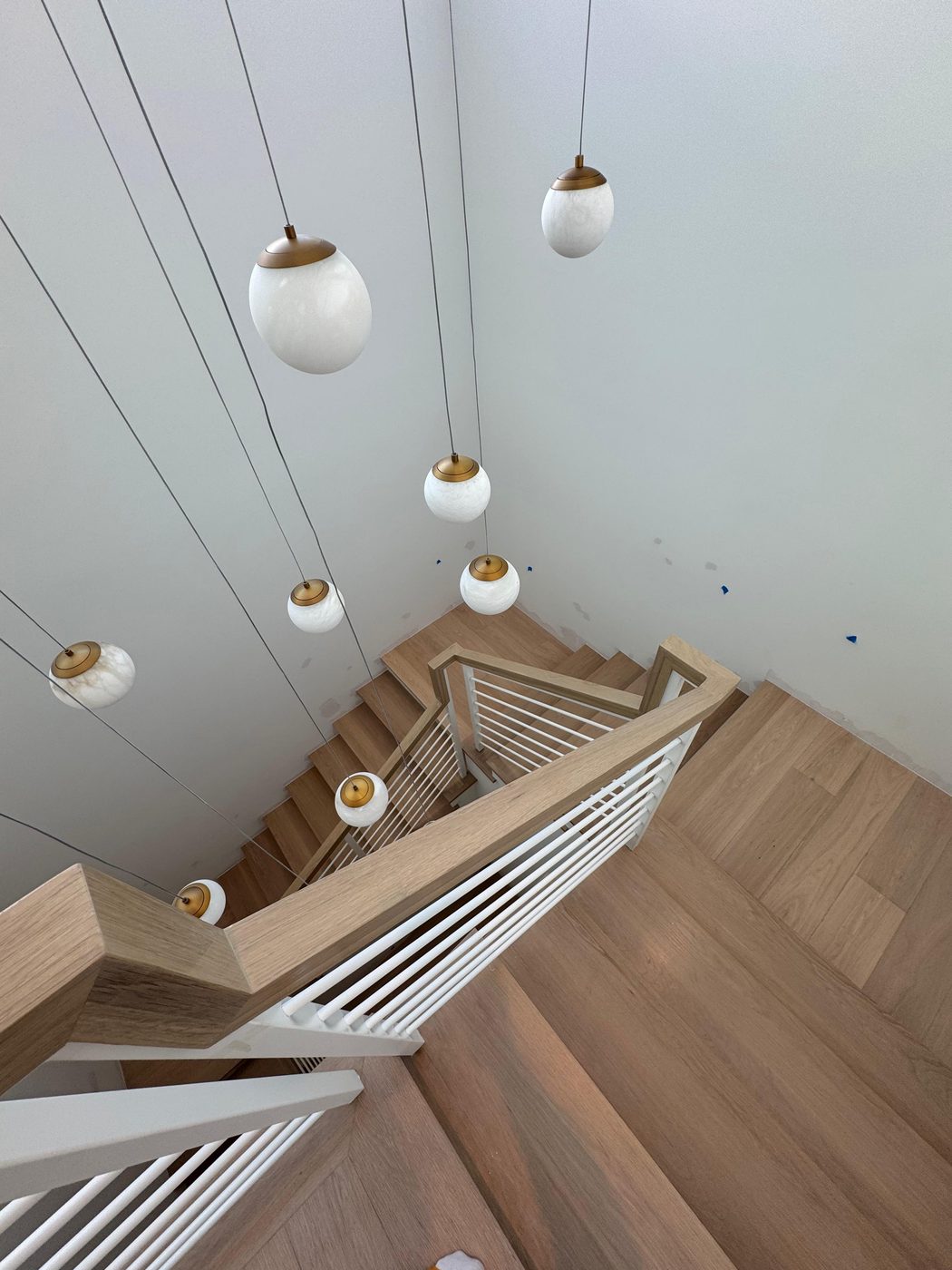 View down a staircase with white rod railings