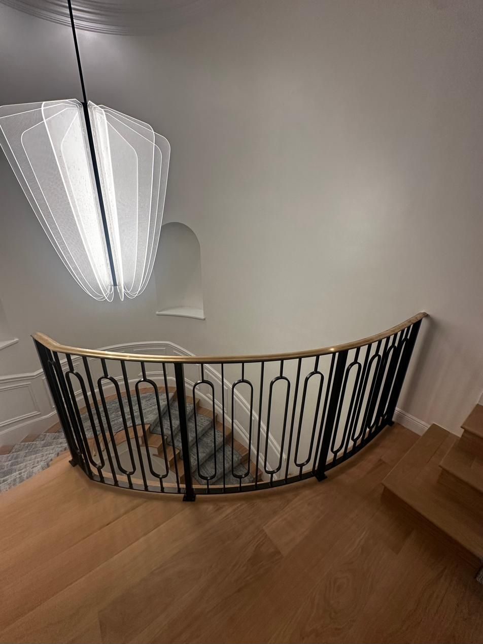 Curved landing railing with ornamental iron