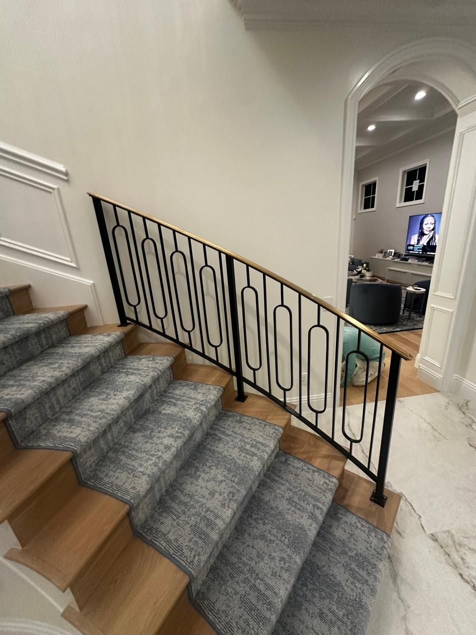 Curved staircase railing with ornamental ironwork